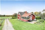 Klassisk svensk rødt-hvidt feriehus ved søen Åsnen