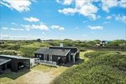 Arkitekttegnet sommerhus med skøn beliggenhed på naturgrund, betagende udsigt til klitter, havkig fra høj terrasse og kun 300 meter til stranden